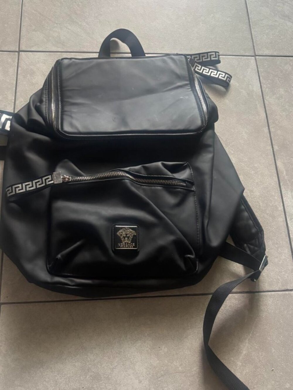 Black Versace backpack with white Greek key pattern on straps